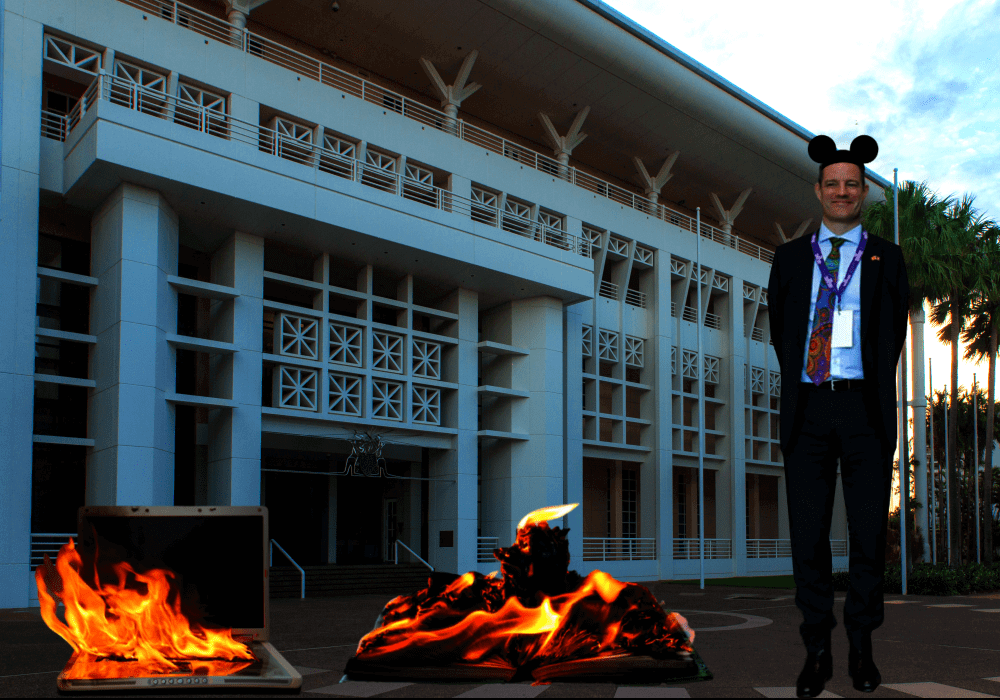 Department of the Chief Minister deputy chief executive Andy Cowan with a burning book and a burning computer